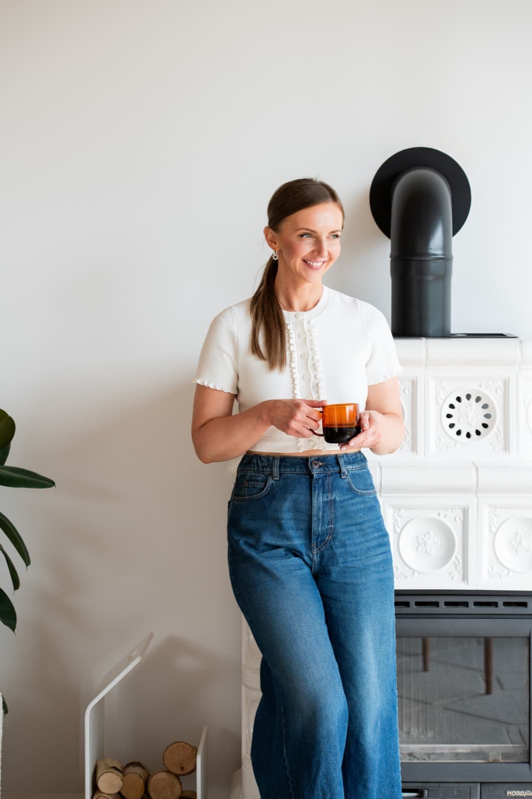 Kasha with a warm drink beside the white tiled stove at The Chocolate Lodge