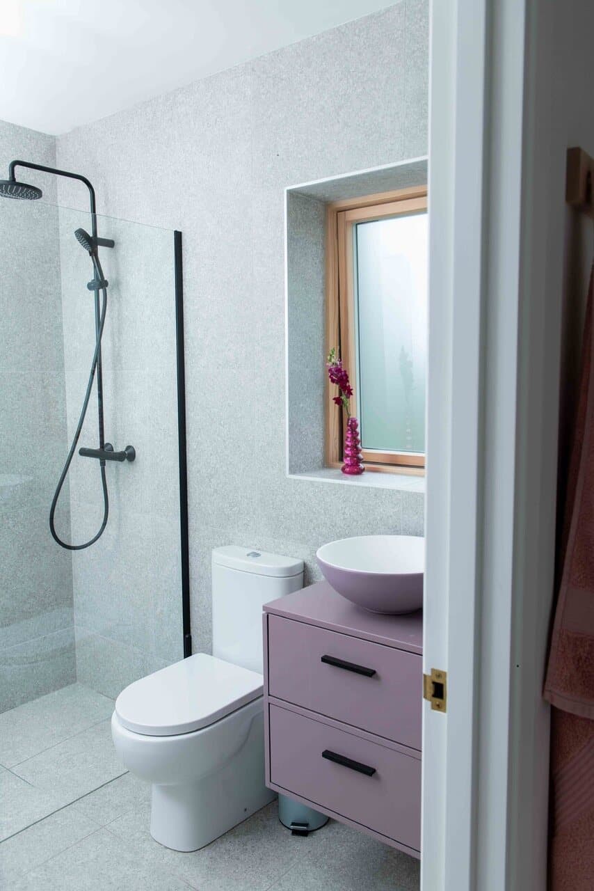 The en-suite bathroom at The Chocolate Lodge, with a walk-in rain shower and a stone-tiled window seat